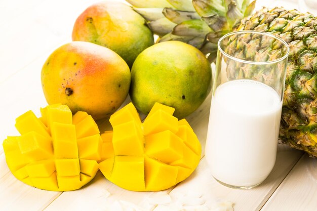 Ingredientes frescos na mesa para fazer smoothie com frutas tropicais.