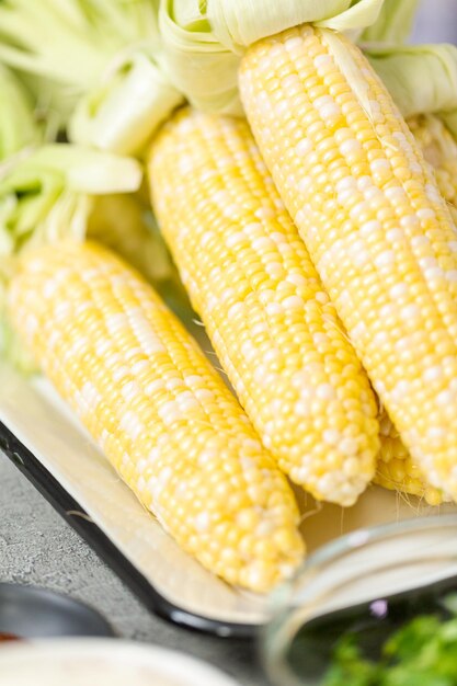 Ingredientes frescos para preparar elote de maíz callejero mexicano a la parrilla.