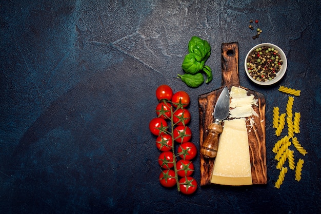 Ingredientes para hacer macarrones crudos sobre una mesa negra