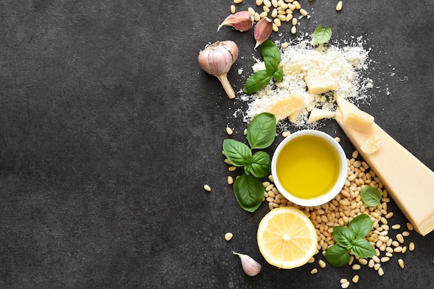 Ingredientes para hacer salsa pesto sobre un fondo de hormigón negro. Vista desde arriba. Proceso de cocina.