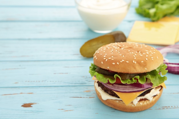 Ingredientes de hamburguesa casera dispuestas en madera azul.