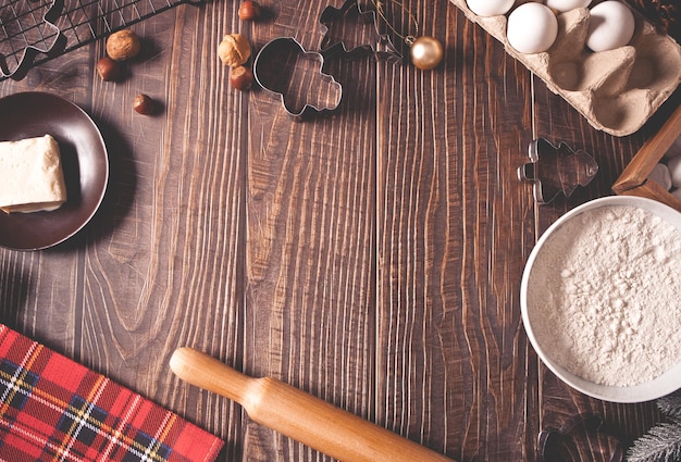 Ingredientes para hornear en casa galletas de Navidad, utensilios de cocina en el fondo de madera. Vista superior. Copie el espacio.