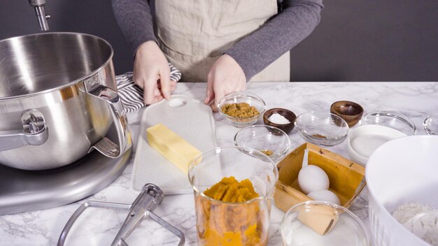 Ingredientes para hornear cupcakes de calabaza y especias sobre una encimera de mármol.