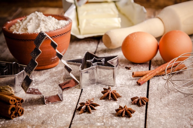 Ingredientes para hornear harina huevos mantequilla y cortadores de galletas de rodillo en una mesa