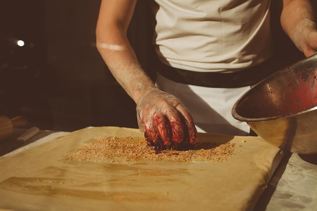 Ingredientes para hornear strudel relleno de cerezas enlatadas. El cocinero está preparando un strudel de cerezas. Estilo rústico. Consulte el paso de la secuencia de recetas en el paso. Manos de un hombre. El chef pone cerezas.