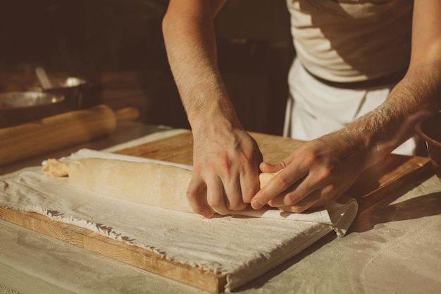 Ingredientes para hornear strudel relleno de cerezas enlatadas. El cocinero está preparando un strudel de cerezas. Estilo rústico. Consulte el paso de la secuencia de recetas en el paso. Manos de un hombre. El chef pone cerezas.