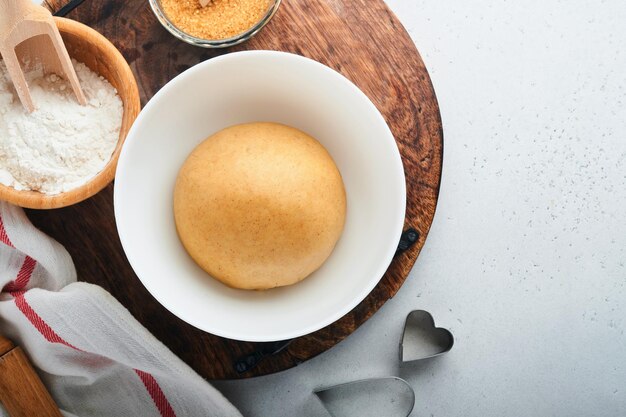 Ingredientes para hornear y utensilios de cocina en una vista superior de fondo blanco Preparación de galletas de azúcar de corazón Fondo para hornear Harina huevos azúcar especias y un batidor en la mesa de la cocina Lay Flat