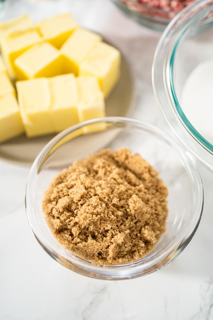 Ingredientes medidos en un tazón de vidrio para preparar galletas de chocolate blanco con menta.