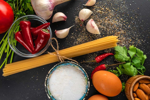 Ingredientes naturales para cocinar pasta, espaguetis crudos atados con una cuerda, sal y pimienta en las mesas