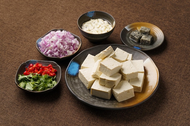 Ingredientes necessários para tofu fedorento frito em um fundo monocromático