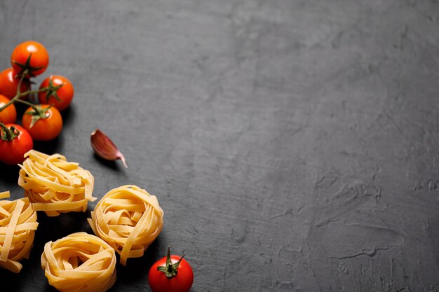 Ingredientes orgânicos frescos de receitas italianas. macarrão, tomate, alho. conceito de comida saudável.