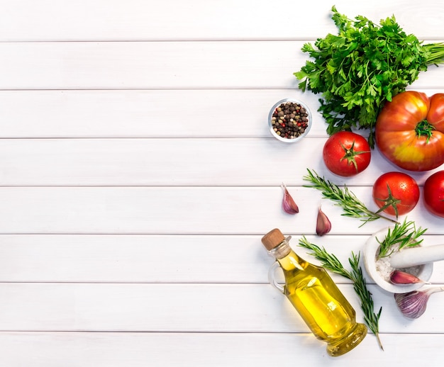 Ingredientes orgánicos frescos de recetas italianas. Concepto de comida sana en el fondo de la mesa de madera blanca. Vista superior, copie el espacio.