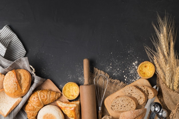 ingredientes de pan y panadería sobre fondo de piedra negra, vista superior y copia espacio para texto de entrada