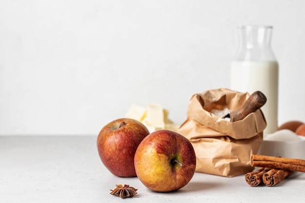 Ingredientes para assar bolo de maçã caseiro ou ovos de farinha de torta, manteiga de açúcar de leite e especiarias em fundo branco com espaço de cópia