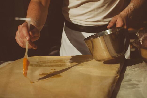 Ingredientes para assar strudel recheado com cerejas em conserva. A cozinheira está preparando um strudel de cereja. Estilo sertanejo. Consulte a etapa da sequência da receita na etapa. Mãos de um homem. O chef coloca cerejas.