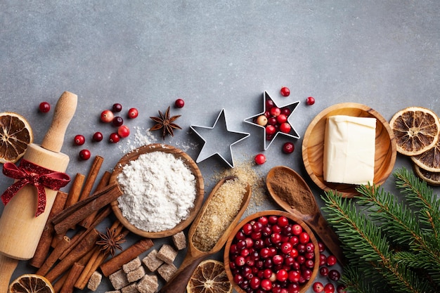 Ingredientes para cozinhar cozimento de Natal Farinha, açúcar, manteiga, cranberry e especiarias na mesa da cozinha