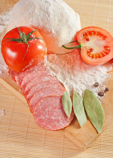 Ingredientes para cozinhar pizza em uma placa de madeira