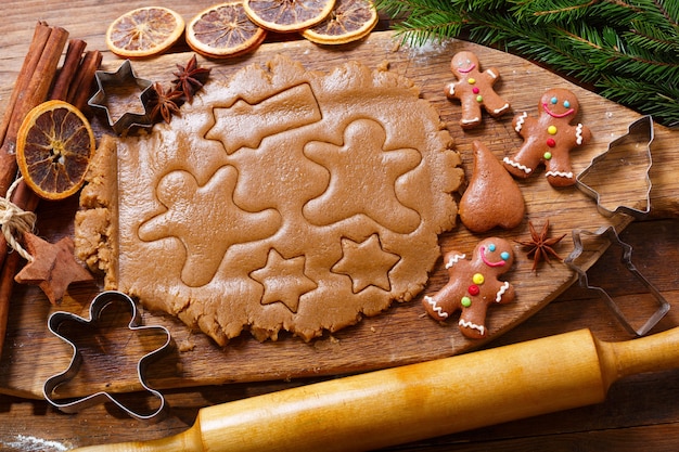 Ingredientes para fazer biscoitos de gengibre de natal. massa para biscoitos e utensílios de cozinha, vista de cima