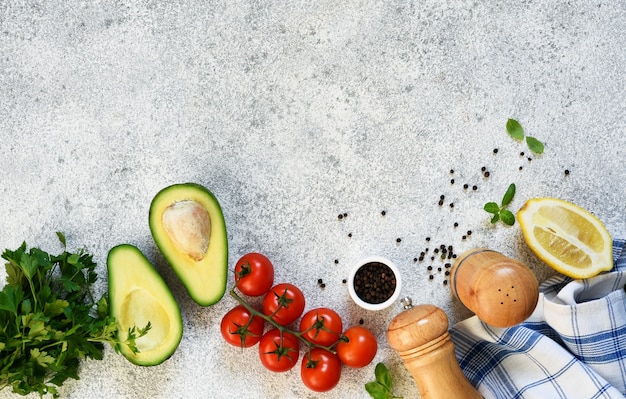 Ingredientes para fazer o molho guacamole. comida em uma mesa de concreto com espaço para texto.