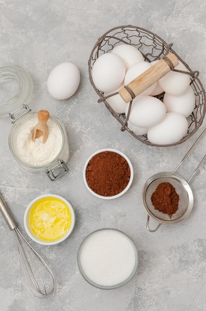 Foto ingredientes para fazer pão de ló de chocolate para rolo ovos farinha manteiga açúcar cacau