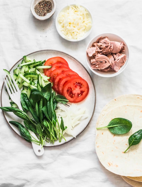 Ingredientes para fazer queijo de atum enlatado de quesadillas e tortilhas em uma vista superior de fundo leve