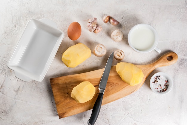 Ingredientes para gratinado de batata na mesa de pedra