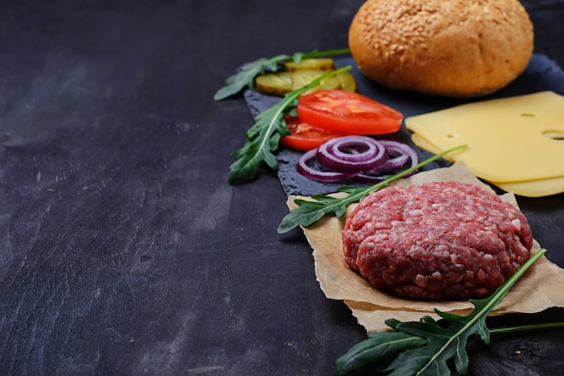 Foto ingredientes para hambúrguer: costeleta crua, tomate, queijo, cebola