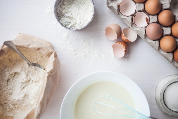 Ingredientes para o bolo de cozimento apresentado em uma tabela de madeira branca. foco seletivo