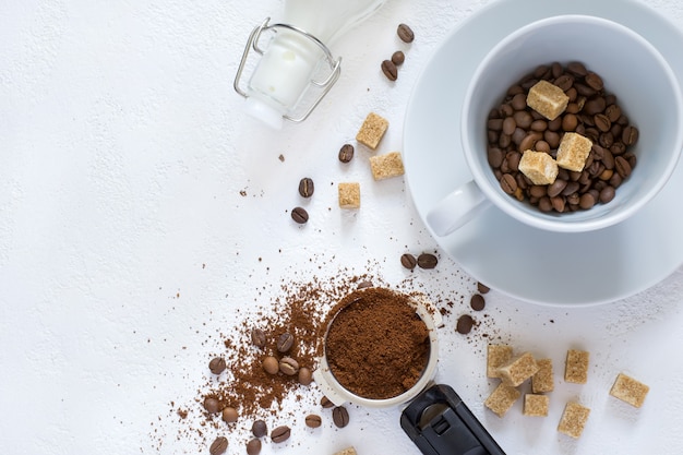 Ingredientes para o café: café moído na buzina da cafeteira, açúcar e uma xícara. vista superior com espaço de cópia