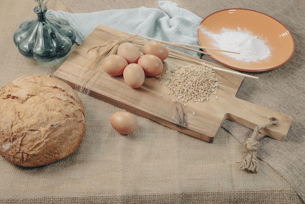 Ingredientes para o preparo do pão sobre uma toalha de mesa rústica.