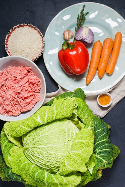 Ingredientes para o repolho de Savoy enchido com carne e vegetais. Cenoura, pimentão, cebola, alho, tomilho, especiarias, arroz