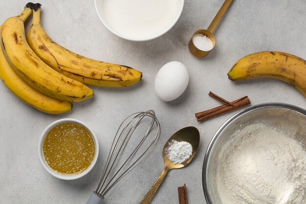 Ingredientes para pão de banana em tigelas na vista superior do plano de fundo cinza claro