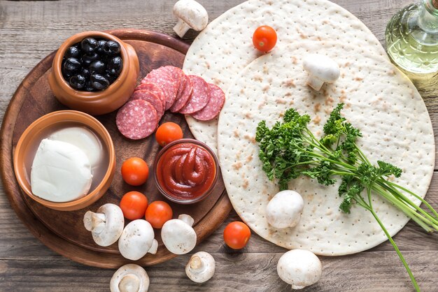 Ingredientes para pizza em um fundo de madeira