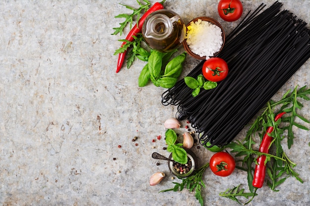 Ingredientes para la pasta de linguini negro: tomate, albahaca, chile. Vista superior