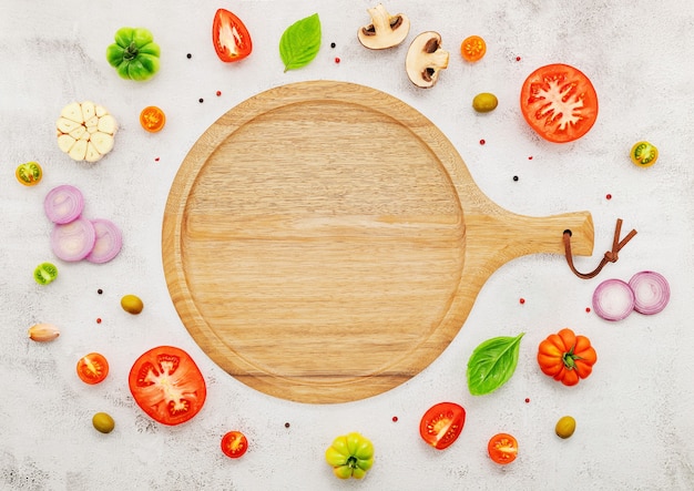 Los ingredientes para la pizza casera sobre fondo de hormigón blanco.