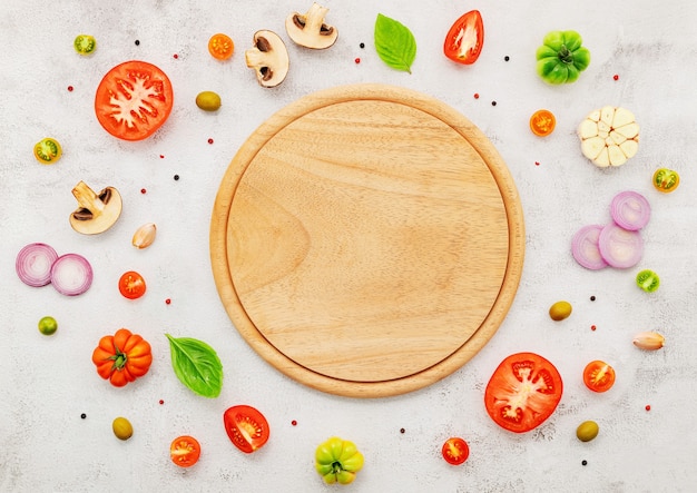 Los ingredientes para la pizza casera sobre fondo de hormigón blanco.