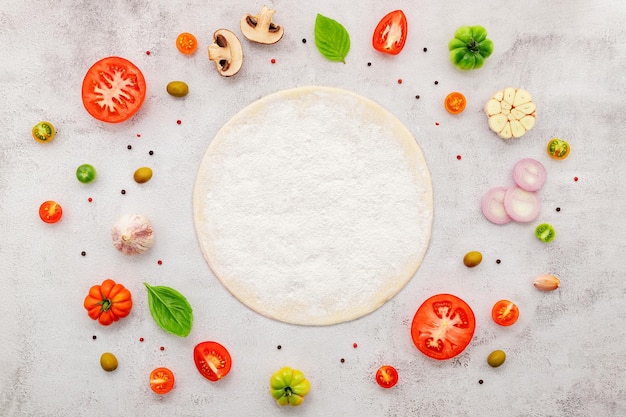 Foto los ingredientes para la pizza casera sobre fondo de hormigón blanco