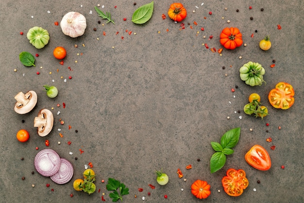 Los ingredientes para la pizza casera sobre fondo de piedra oscura.