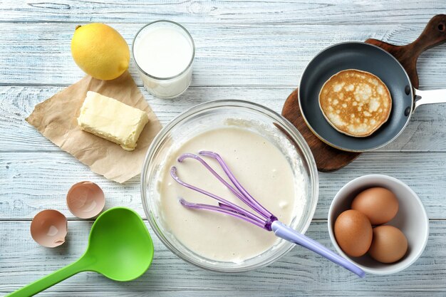 Ingredientes para la preparación de panqueques sobre fondo de madera