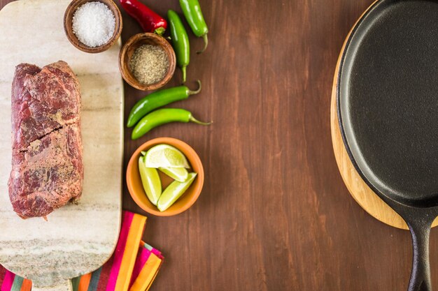 Ingredientes para preparar fajitas de bistec en una mesa de madera.