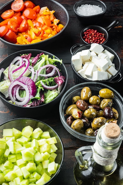 Ingredientes principais da salada grega: mistura de azeitonas frescas, queijo feta, tomate, pimenta, no fundo da velha mesa de madeira escura