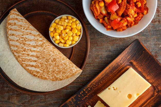 Ingredientes para quesadilla, burito, taco, sobre mesa de madera.