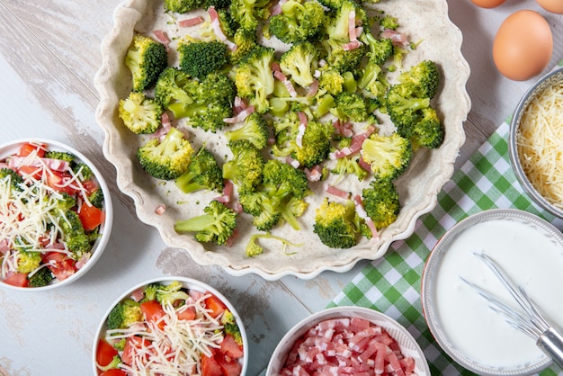 Foto ingredientes para quiche con brócoli, queso y tomates.