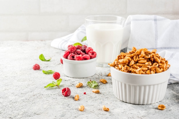 Ingredientes saludables para el desayuno. Cereal de desayuno, vaso de leche o yogurt, frambuesas