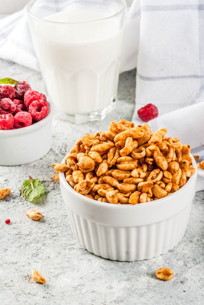 Ingredientes saludables para el desayuno. Desayuno cereal leche o yogur frambuesas de vidrio y menta sobre fondo de piedra gris