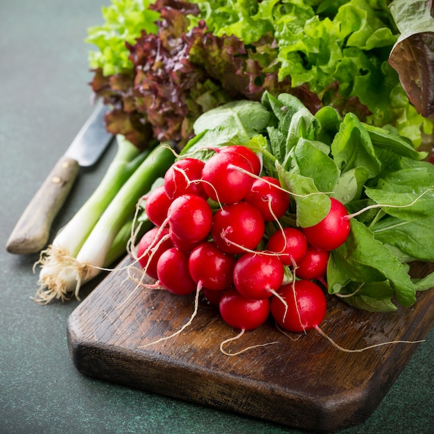 Ingredientes saudáveis para salada na velha placa de corte de madeira.