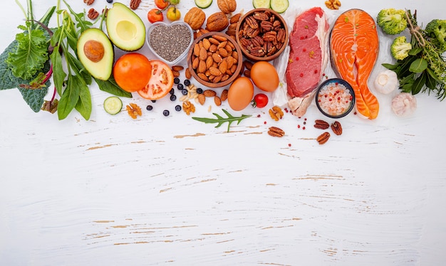 Ingredientes para la selección de alimentos saludables sobre fondo blanco de madera.