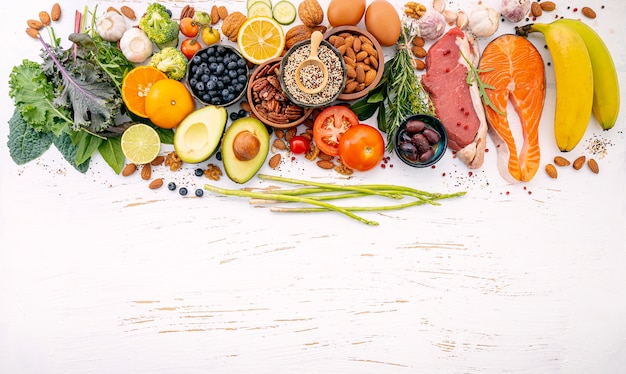 Ingredientes para la selección de alimentos saludables sobre fondo blanco de madera.