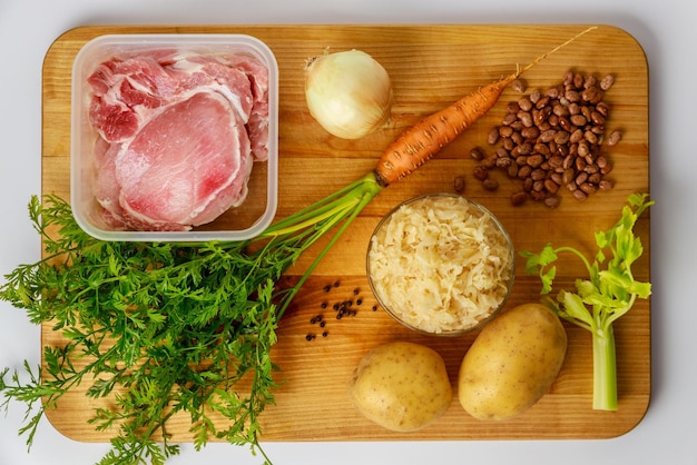 Los ingredientes en una tabla de madera para hacer sopa de chucrut