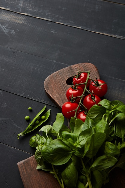 Ingredientes vegetales para ensalada de tomates con albahaca y guisantes